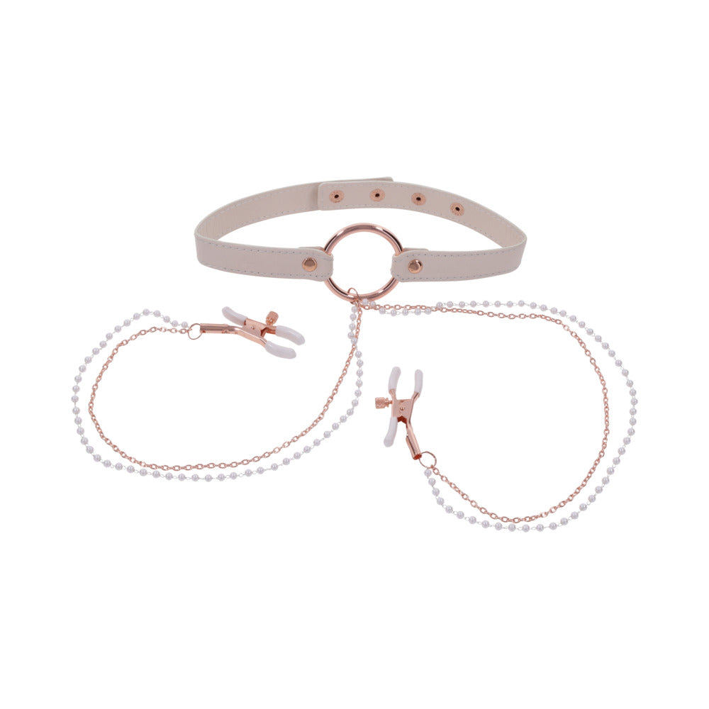 The Peaches 'n Cream Collar and Nipple Clamps by Sportsheets features a beige choker with a central ring that serves as an adjustable collar, linked to two nipple clamps via delicate pearl-embellished chains. The clamps are equipped with white silicone tips, and the design is highlighted by rose gold hardware accents.