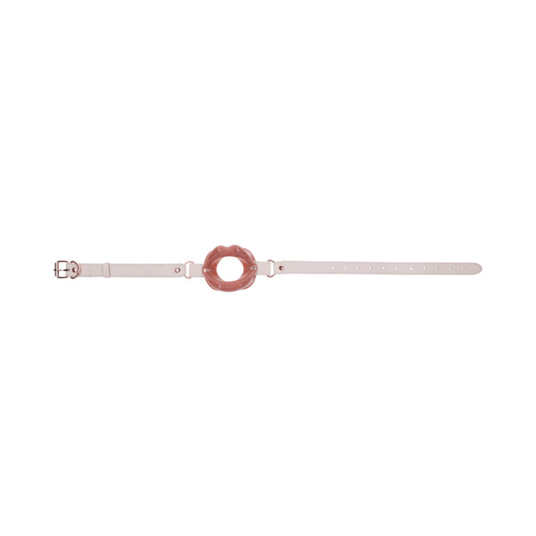 A beige adjustable strap with the Peaches 'n Cream Silicone Lips Open Mouth Gag, featuring a circular pink silicone centerpiece. The Sportsheets strap includes a buckle for secure fastening, combining style and practicality.