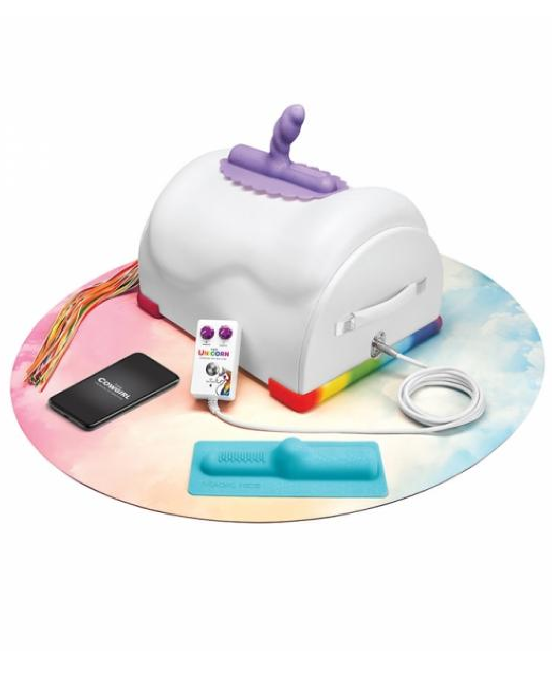 The Cowgirl Unicorn Premium Sex Machine on rainbow mat with remote and attachments