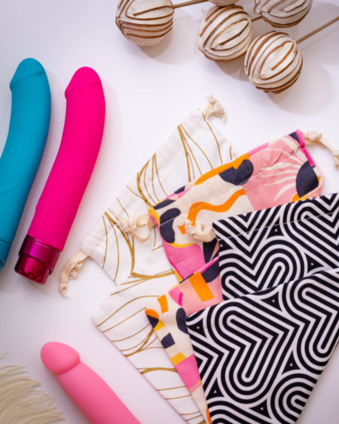 Blush Bomba Black & White Sex Toy Storage Bag next to vibrators and other bags