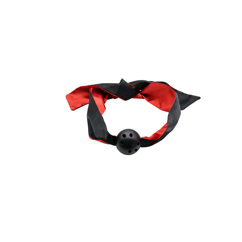 A black and red silky ribbon loops around a holed black ball against a white background—the Sensual Scarlet Nights Beginner Bondage Collection for Curious Couples adds elegance to your sensual adventures.