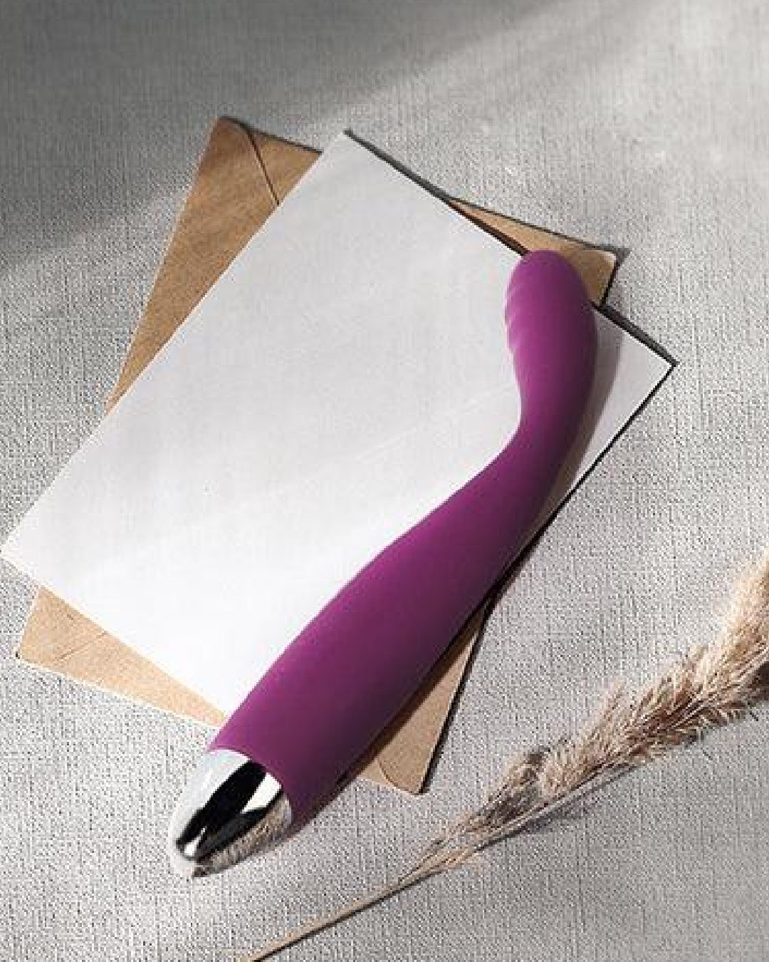 Svakom Cici Flexible G Spot Vibrator on notepad with feather on background 
