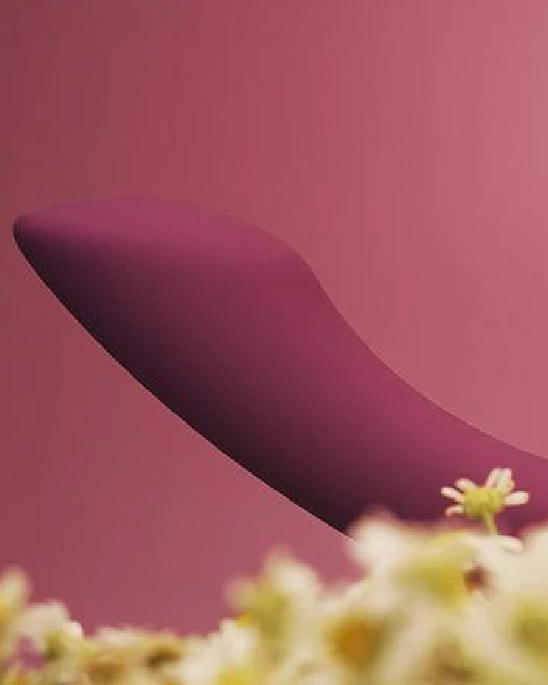 Svakom Amy 2 Flexible G-Spot Vibrator tip on burgundy background with yellow flowers 