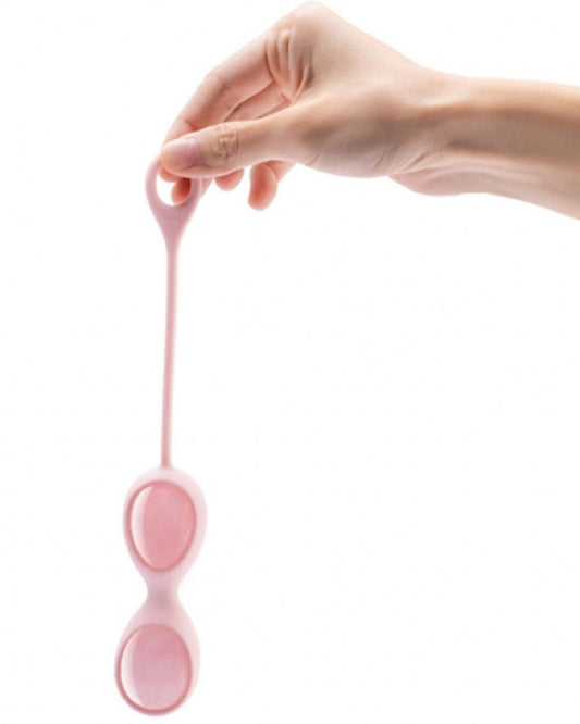 Le Wand Crystal Yoni Eggs - Rose Quartz in silicone casing held in model's hand 