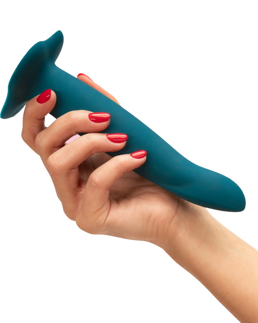 Fun Factory Limba Flex Medium Silicone Dildo - Deep Sea Blue held in a person's hand wearing red nail polish, showing the size of the dildo
